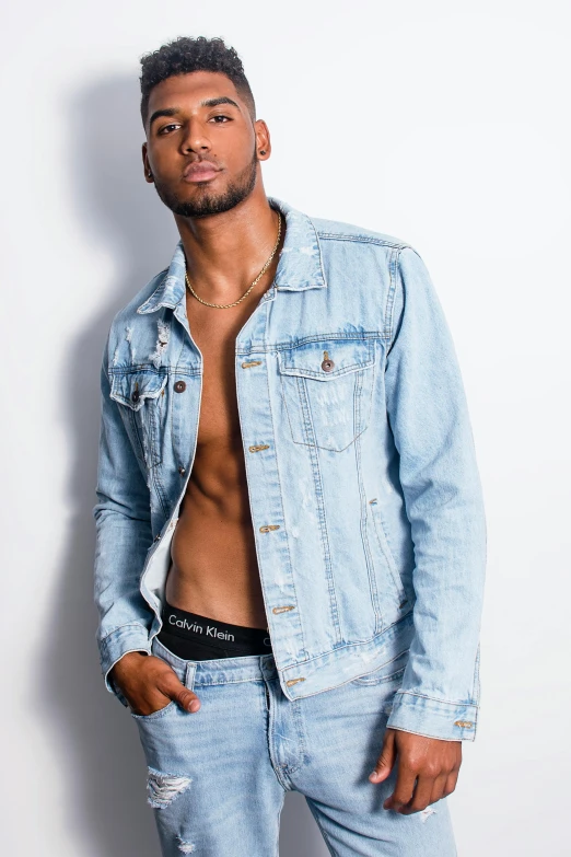 a shirtless man standing in front of a white wall, an album cover, inspired by Charles Alston, trending on pexels, denim jacket, transparent background, wearing a light blue shirt, professional modeling