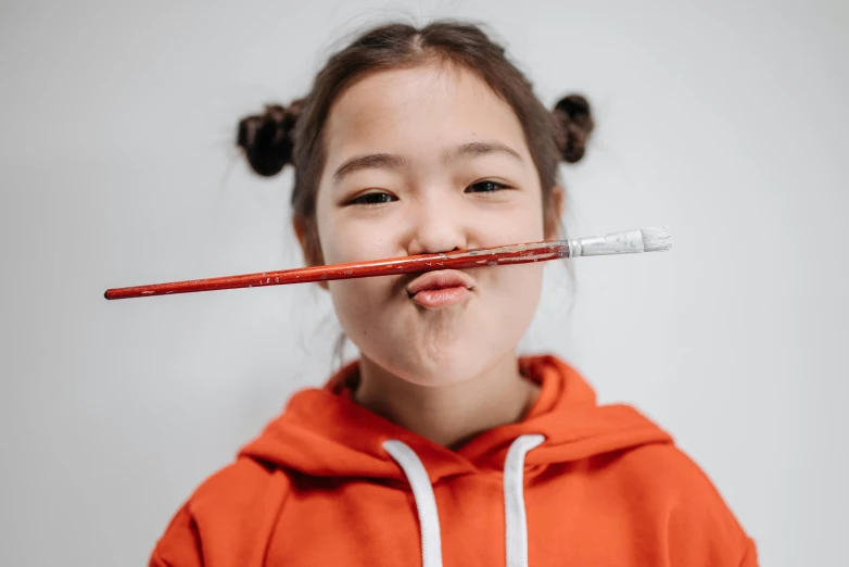 a young girl brushing her teeth with a toothbrush, pexels contest winner, graffiti, wan adorable korean face, bow and arrow, avatar image, red hot soldering iron