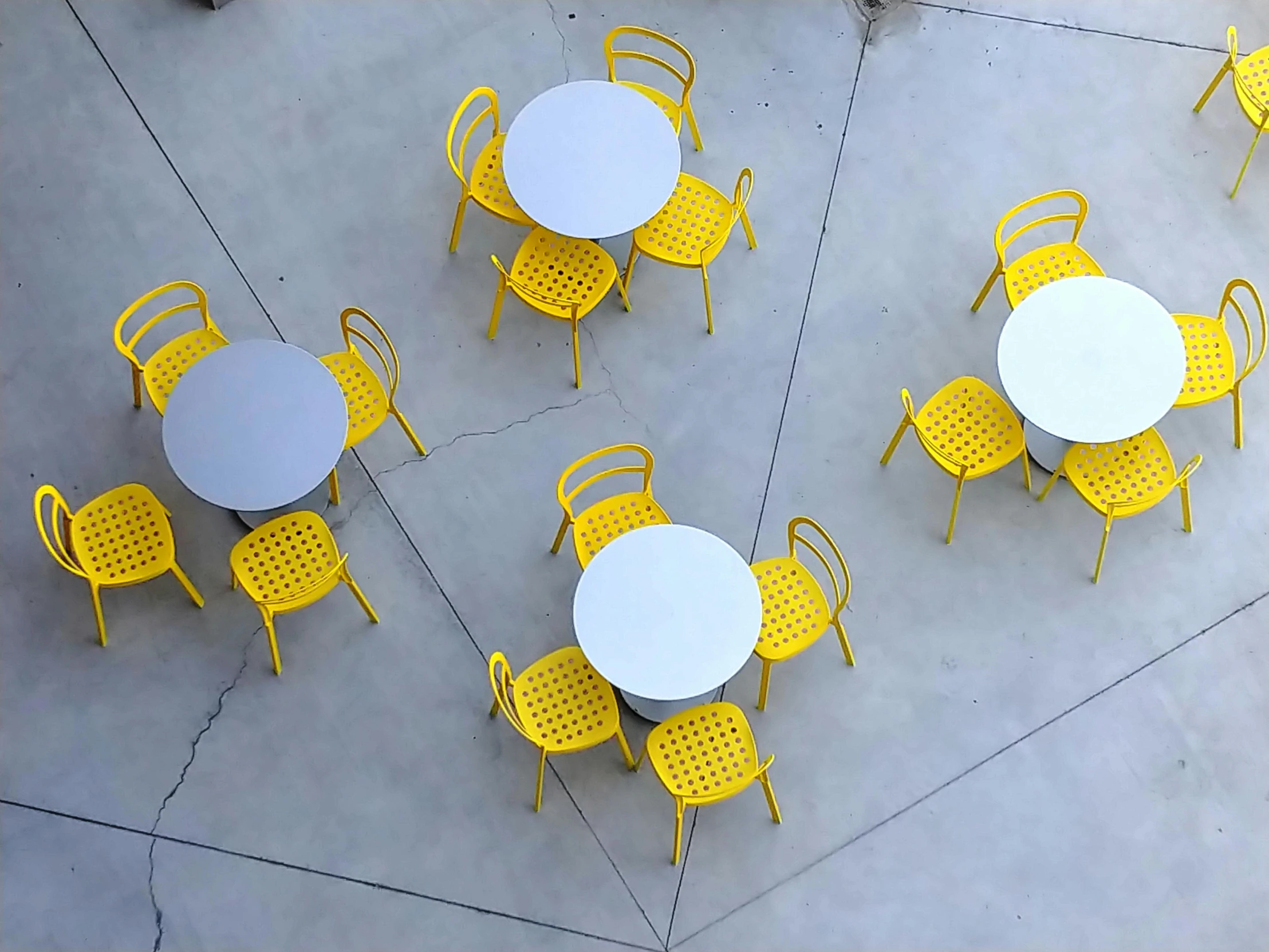 a group of yellow and white tables and chairs, inspired by William Berra, pexels contest winner, looking down on the camera, polished concrete, los angelos, eating