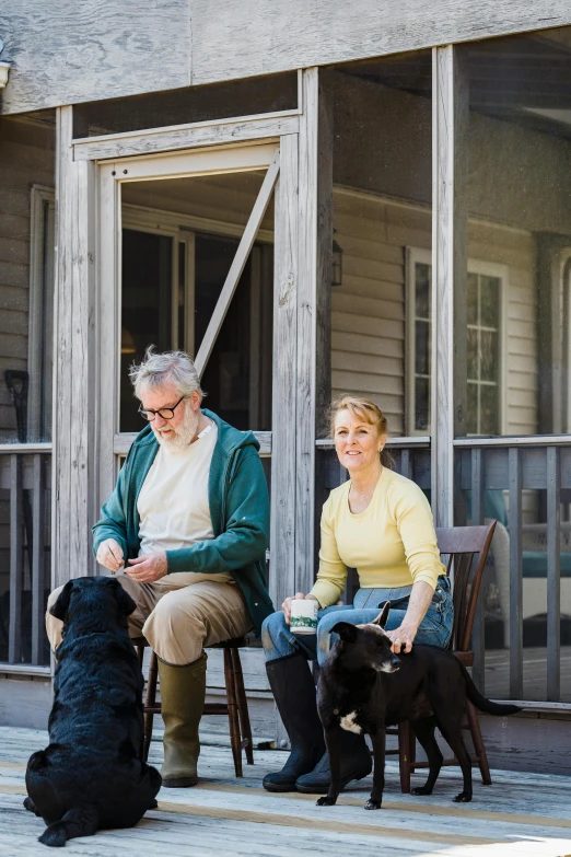 a man and woman sitting on a porch with their dogs, inspired by Norman Rockwell, unsplash, actors, big sky, people walking around, production still