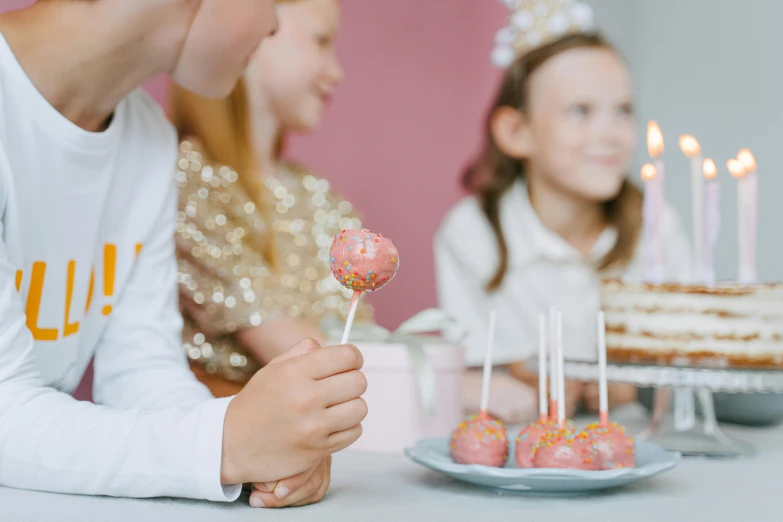 a couple of kids sitting at a table with a cake, pexels contest winner, bubblegum pop, princess in foreground, glittery, serving suggestion