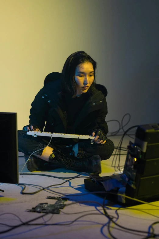 a woman sitting on the floor playing a guitar, inspired by Wang E, video art, cables and monitors, like a cyberpunk workshop, kpop, using synthesizer