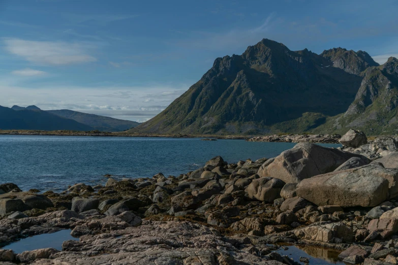 a large body of water with mountains in the background, by Roar Kjernstad, pexels contest winner, hurufiyya, rocky beach, avatar image, panoramic, gigapixel photo