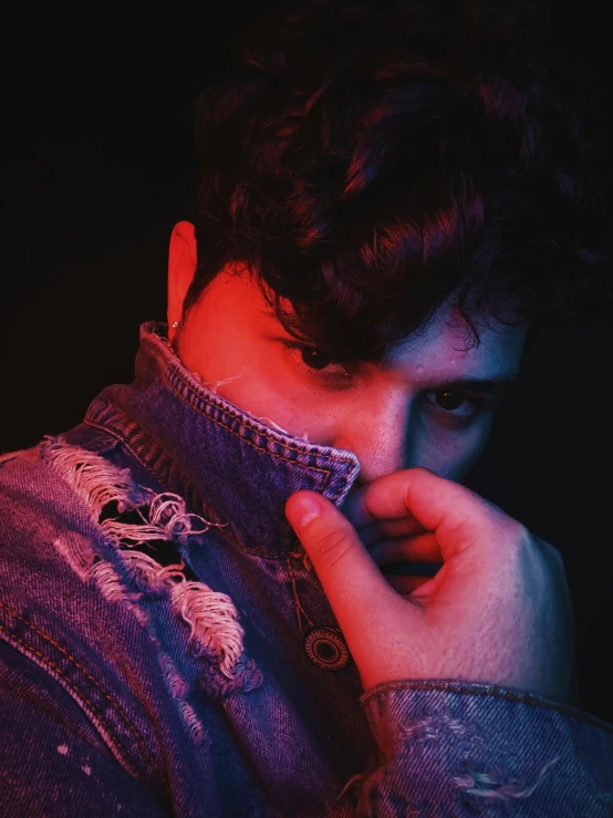 a close up of a person wearing a denim jacket, an album cover, by Adam Dario Keel, shy looking down, red light, curls on top, color splash