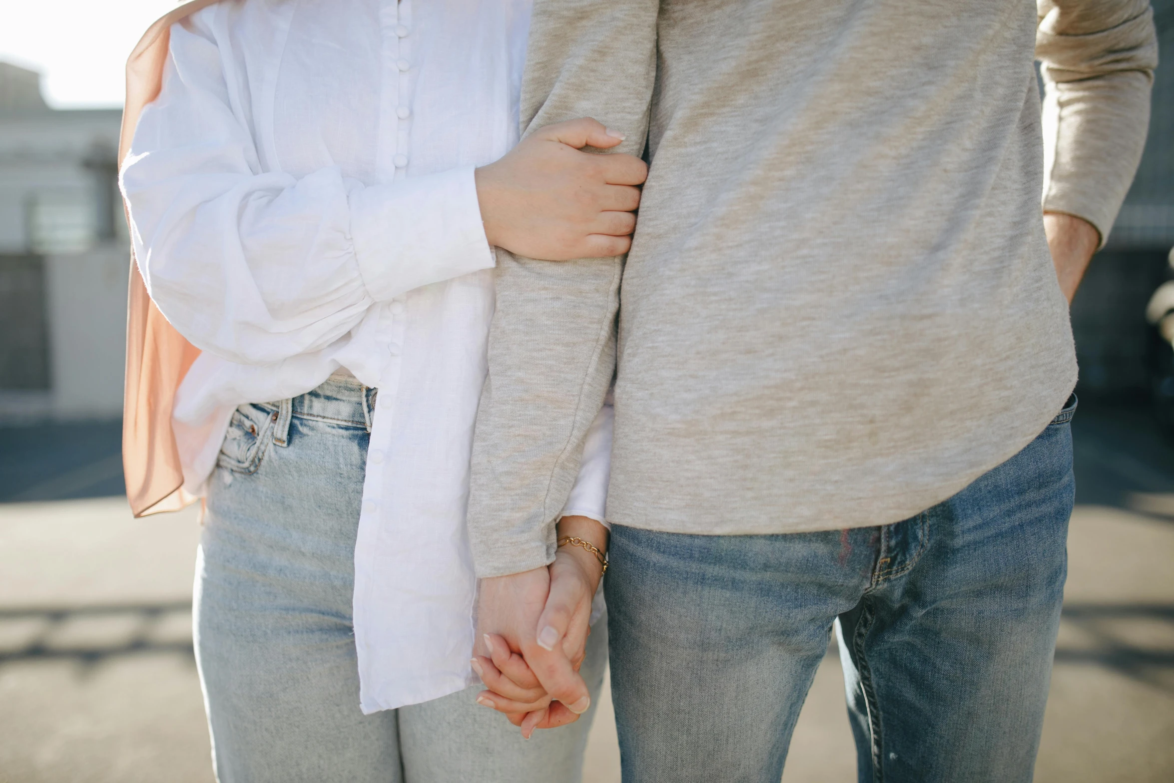 a man and woman standing next to each other holding hands, trending on pexels, woman holding another woman, wearing a light shirt, cuddly, white sleeves