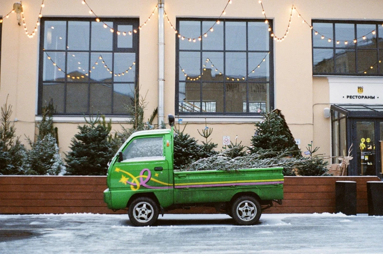 a green truck parked in front of a building, by Julia Pishtar, auto-destructive art, festive atmosphere, only snow in the background, van, high quality upload