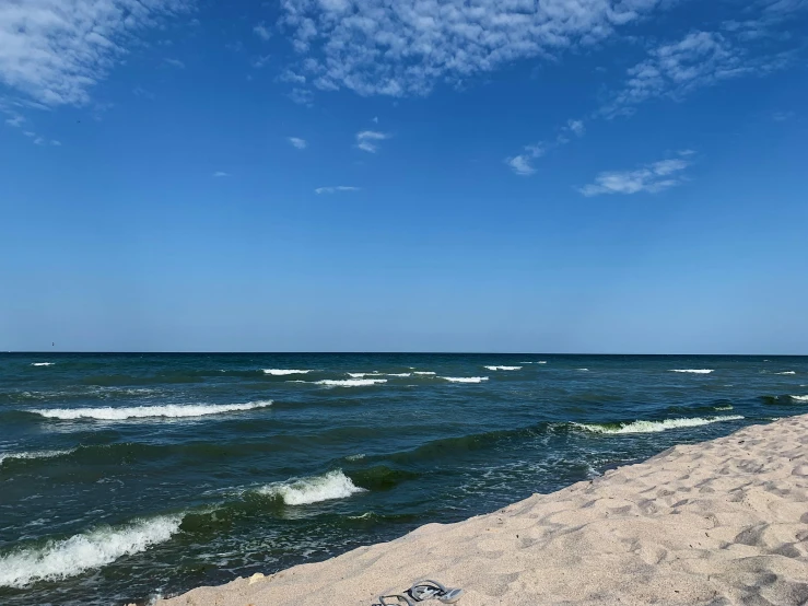 a bench sitting on top of a sandy beach next to the ocean, a picture, unsplash, mingei, a green, waving, from wheaton illinois, profile image