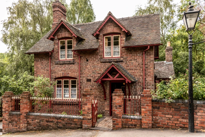 a brick house sitting on the side of a road, arts and crafts movement, cottagecore, profile image, woodland location, brown