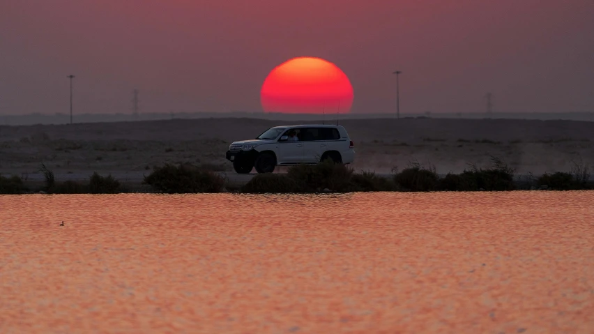 a truck that is sitting in the dirt, pexels contest winner, water reflecting suns light, tanned ameera al taweel, red sun over paradise, sunset panorama