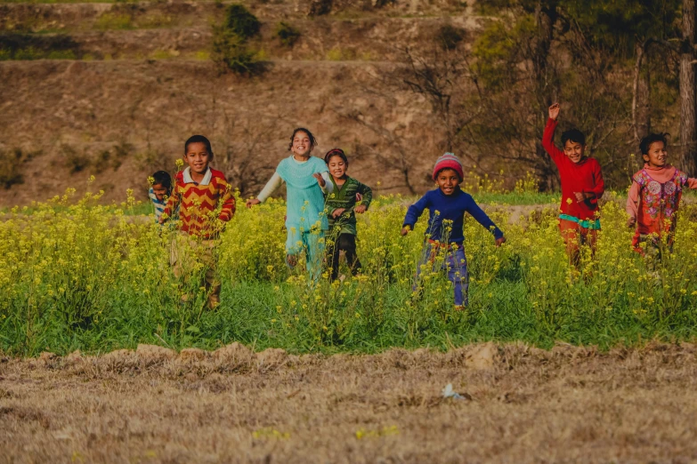 a group of children running through a field, pexels contest winner, uttarakhand, avatar image, mustard, diverse