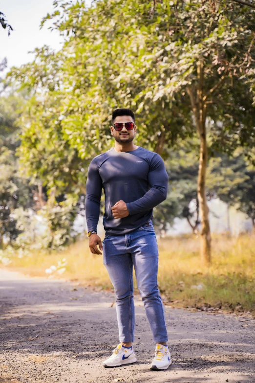 a man standing in the middle of a road, showing strong muscles, uploaded, desi, wearing tight simple clothes