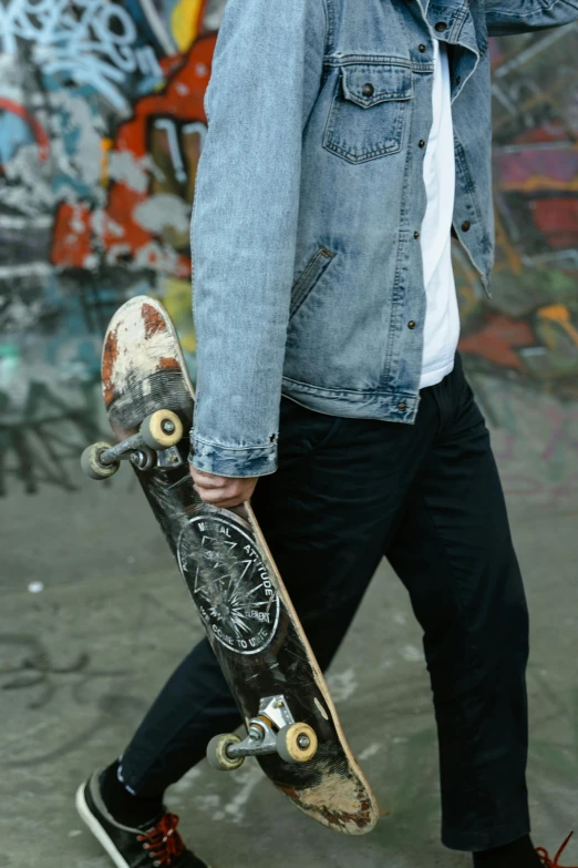 a man walking with a skateboard in his hand, trending on unsplash, wearing a jeans jackets, headshot, intricate detail, wearing jeans and a black hoodie