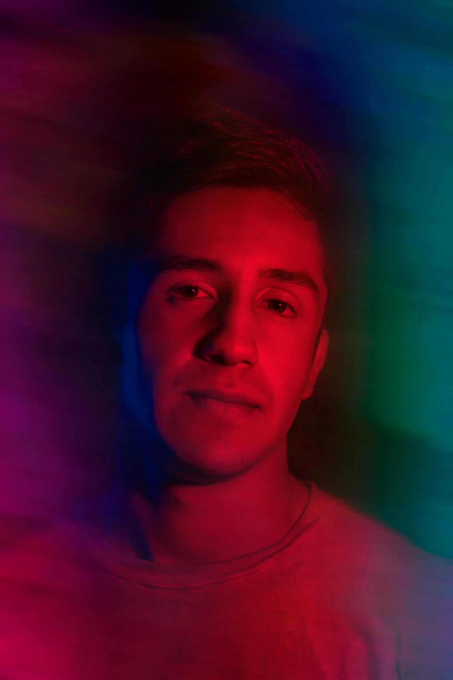 a man standing in front of a colorful background, bisexual lighting, slightly tanned, asher duran, very grainy