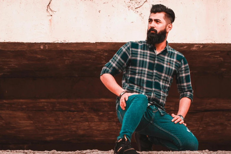 a man with a beard sitting on the ground, pexels contest winner, plaid shirt, teal color graded, model posing, wearing only pants