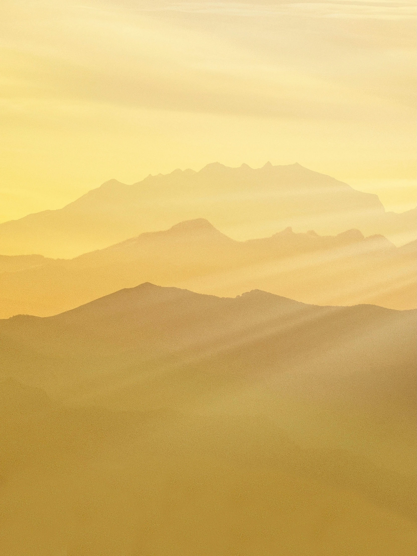 a plane flying over a mountain range at sunset, by Johannes Voss, pexels contest winner, romanticism, gradient yellow, layered fog, shafts of light, gold layers