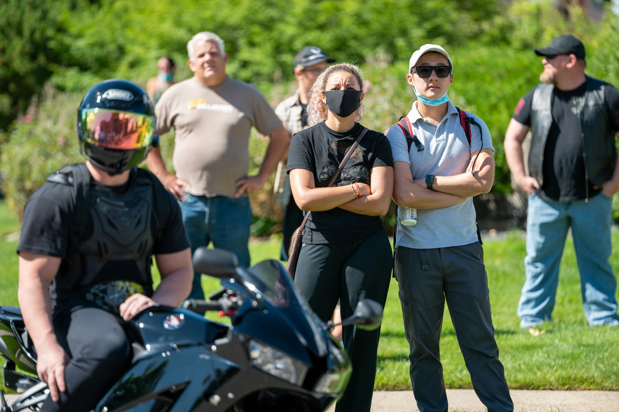 a group of people standing around a motorcycle, wearing facemask and sunglasses, greg rutwoski, avatar image, spectators