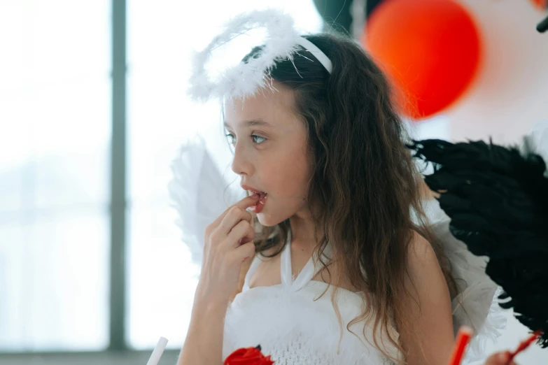 a little girl dressed up as an angel, inspired by Marie Angel, pexels contest winner, eating, soft devil queen madison beer, at a birthday party, teenage girl