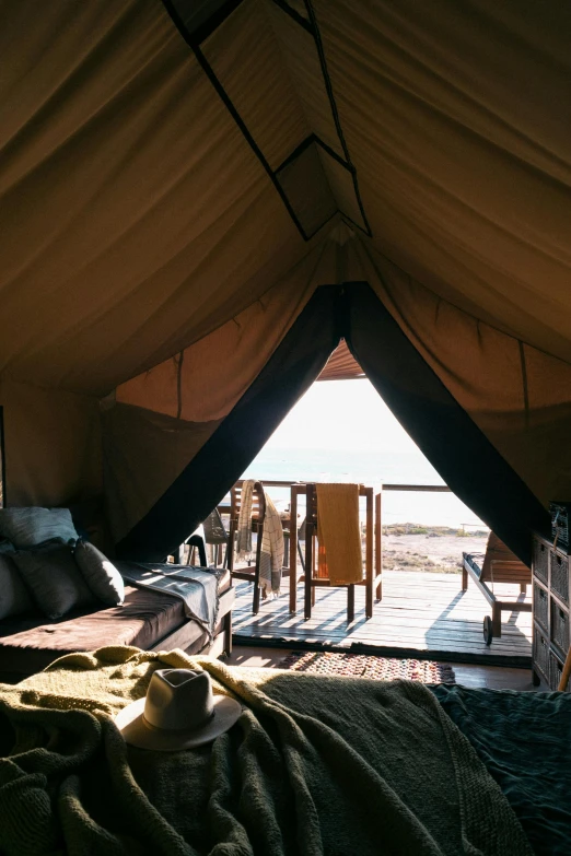 a bed sitting inside of a tent next to a window, overlooking the ocean, aerial shot, sanctuary, awnings