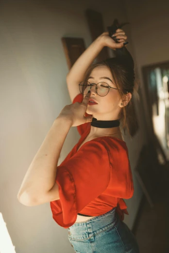 a woman wearing glasses and a red top, by Julia Pishtar, trending on pexels, renaissance, a black choker, indoor picture, doing an elegant pose, morning lighting