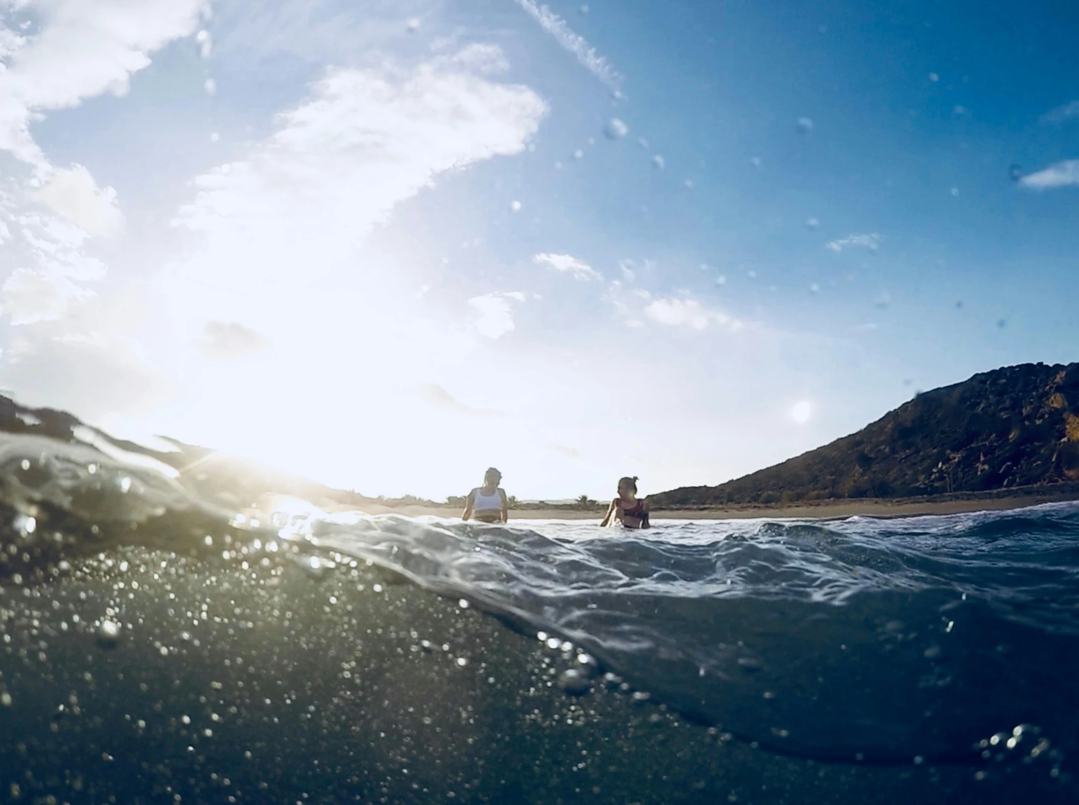 a man riding a wave on top of a surfboard, by Jessie Algie, unsplash contest winner, low wide angle, hollister ranch, view from the sea, male and female