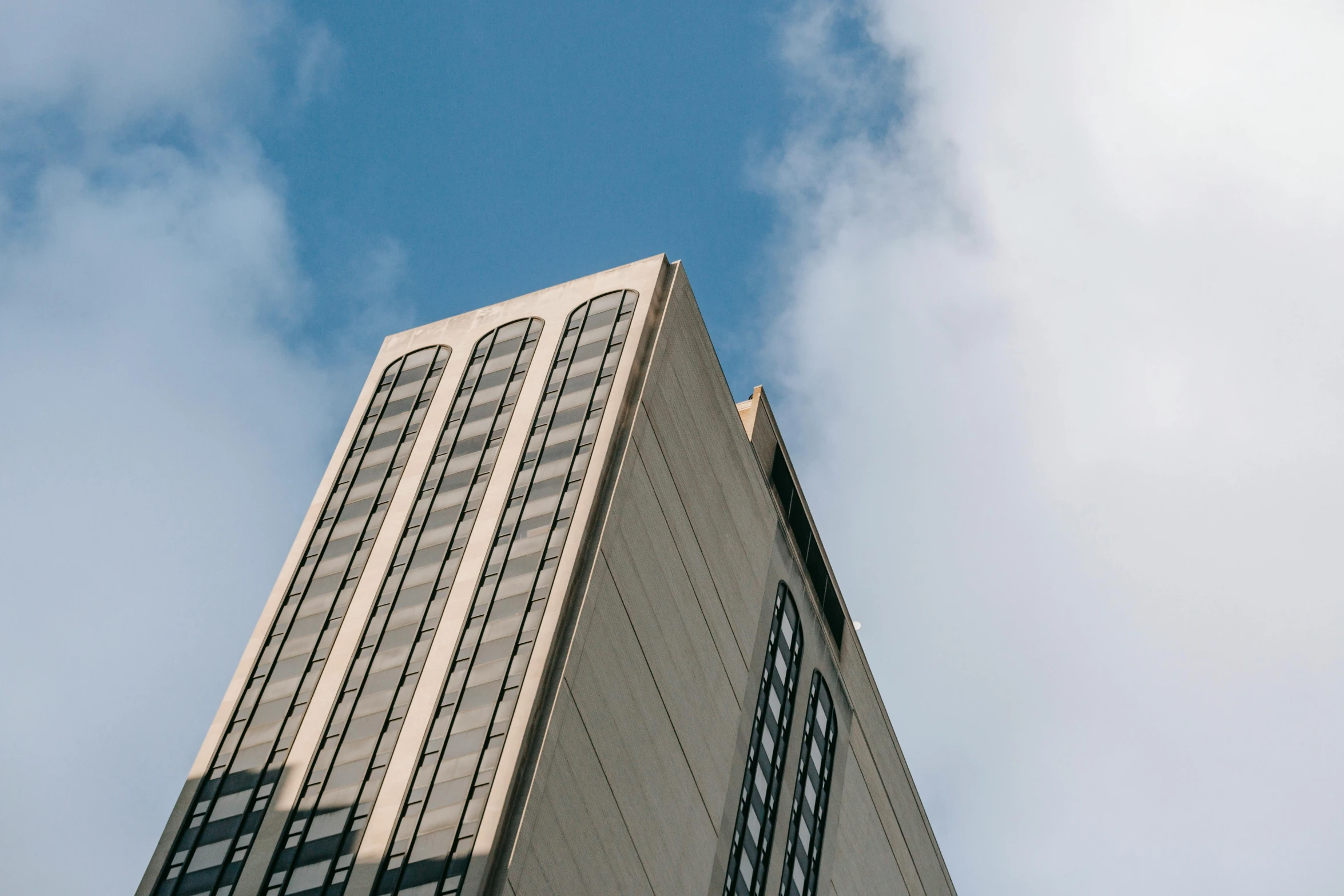 a tall building with a clock on top of it, inspired by Richard Wilson, unsplash, brutalism, up-angle view, 1 4 9 3, grey, sky - high view