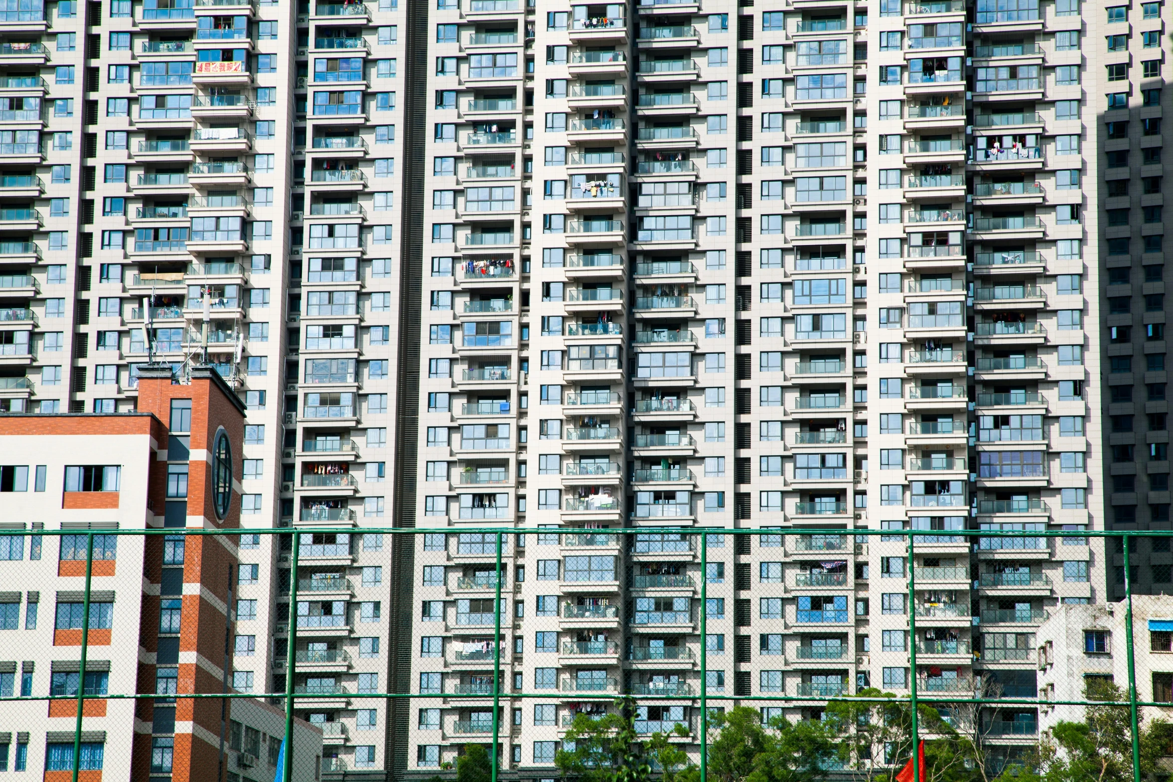 a couple of tall buildings sitting next to each other, a portrait, inspired by Thomas Struth, unsplash, baotou china, ten flats, many windows, a green