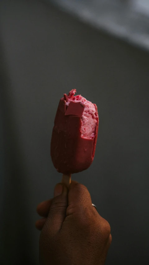 a person holding a pink ice cream on a stick, unsplash, dark red, dark-skinned, tulip, made of glazed