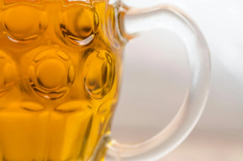 a close up of a glass of beer, by Adam Marczyński, pexels, hyperrealism, voronoi, close up shot from the side, honey, tournament