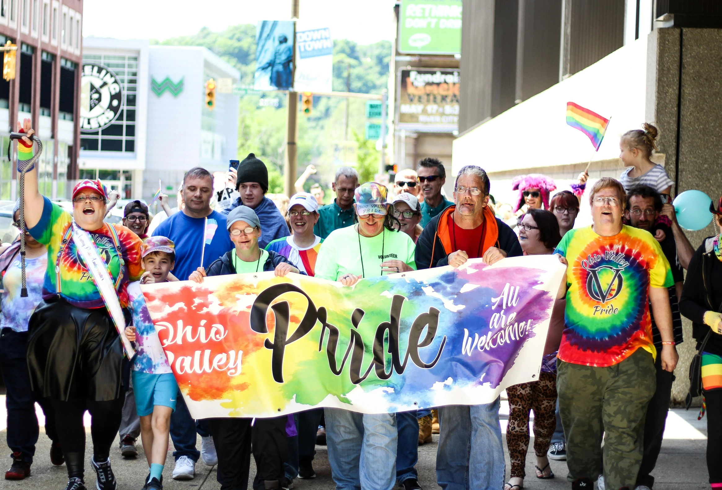 a group of people walking down a street holding a pride banner, a photo, owsley, pittsburgh, profile image, fan favorite