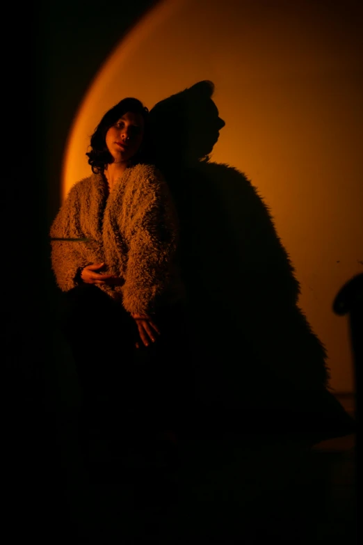 a woman sitting on a chair in the dark, dramatic soft shadow lighting, standing under a beam of light, photographed for reuters, jenny seville