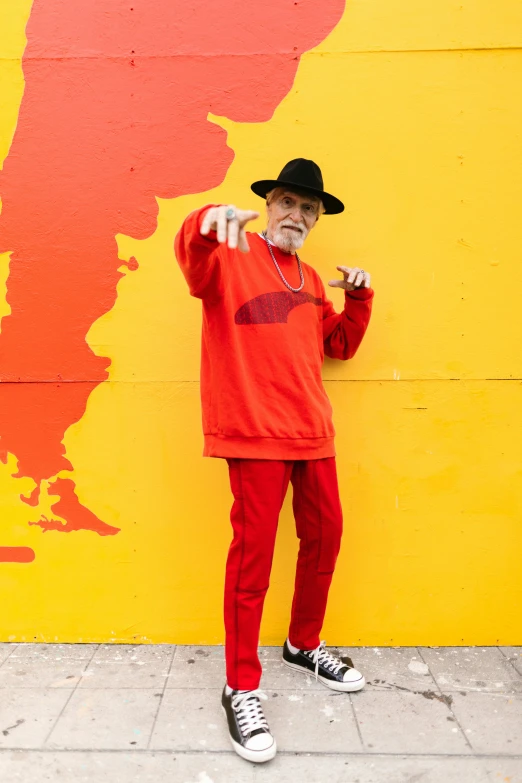 a man that is standing in front of a wall, inspired by Graham Forsythe, graffiti, wearing red and yellow clothes, an oldman, grimes, 🚿🗝📝