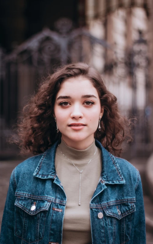 a close up of a person wearing a jacket, pexels contest winner, renaissance, portrait sophie mudd, (dark shorter curly hair), standing in a city center, promotional image