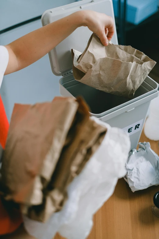 a little boy that is standing in front of a trash can, pexels contest winner, process art, ingredients on the table, brown paper, packaging, ripped up white garment