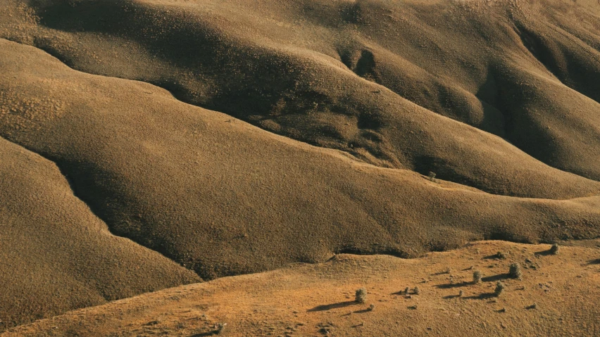 a group of people riding horses across a desert, an album cover, unsplash contest winner, australian tonalism, “ aerial view of a mountain, erosion algorithm landscape, 1990 photograph, hillside