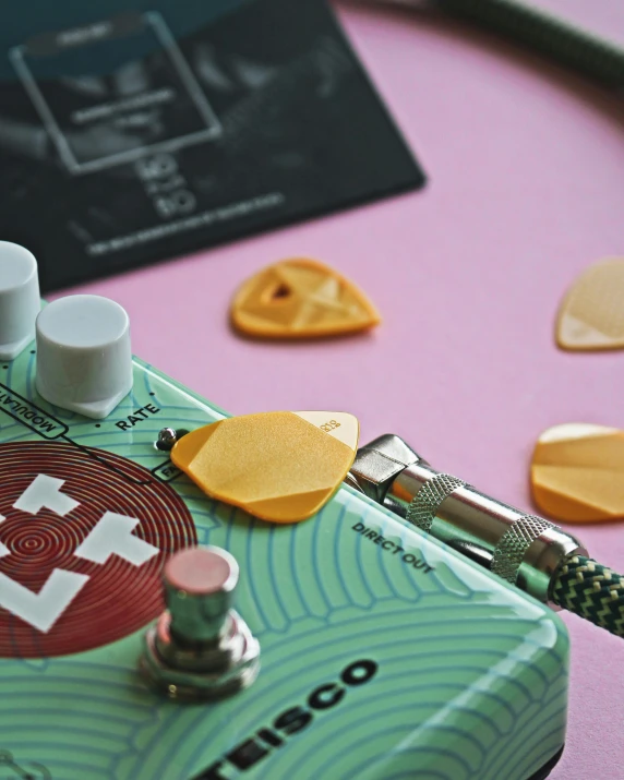 a guitar pedal sitting on top of a pink table, inspired by Elsa Bleda, trending on pexels, lyco art, close up face detail, pills, on grey background, bass sound waves on circuitry