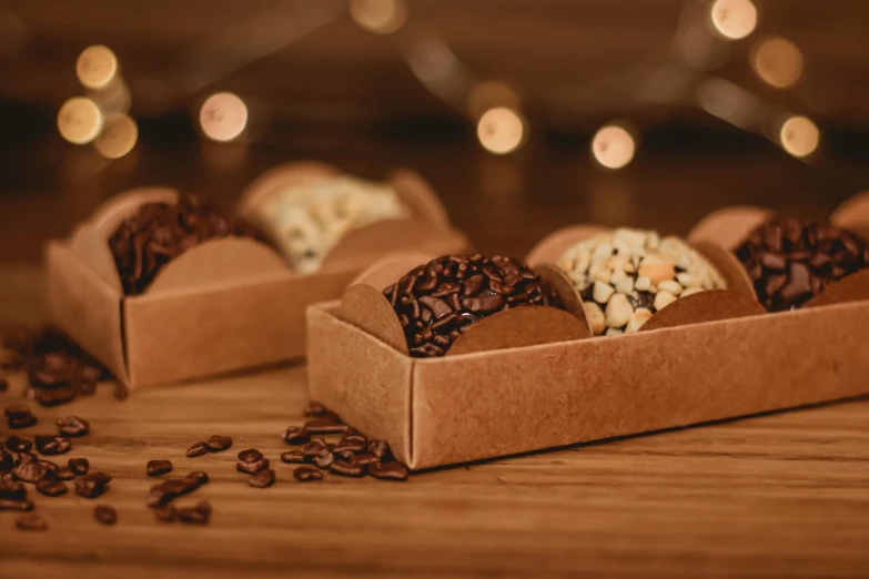 a box of cookies sitting on top of a wooden table, coffee beans, chocolate river, in a row, profile image