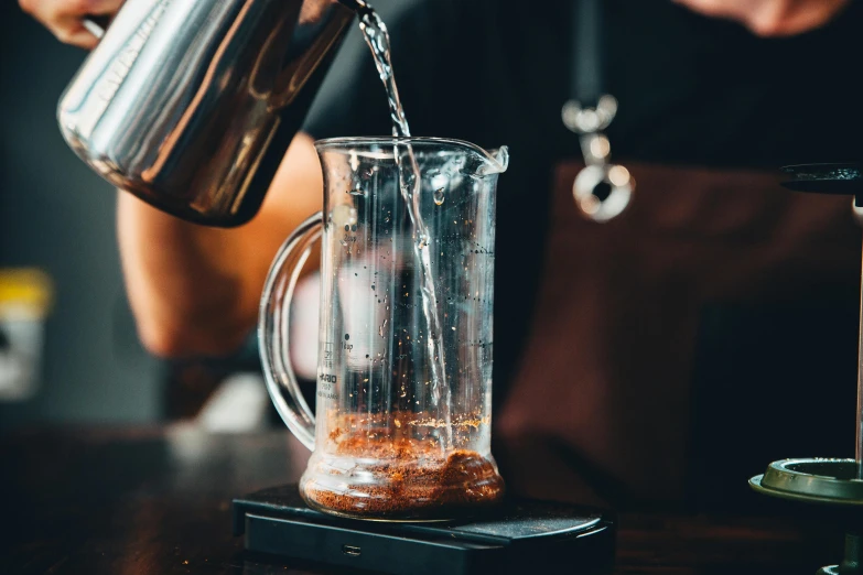 a person pours water into a pitcher, a screenshot, by Niko Henrichon, pexels contest winner, aussie baristas, hour glass, cooked, french