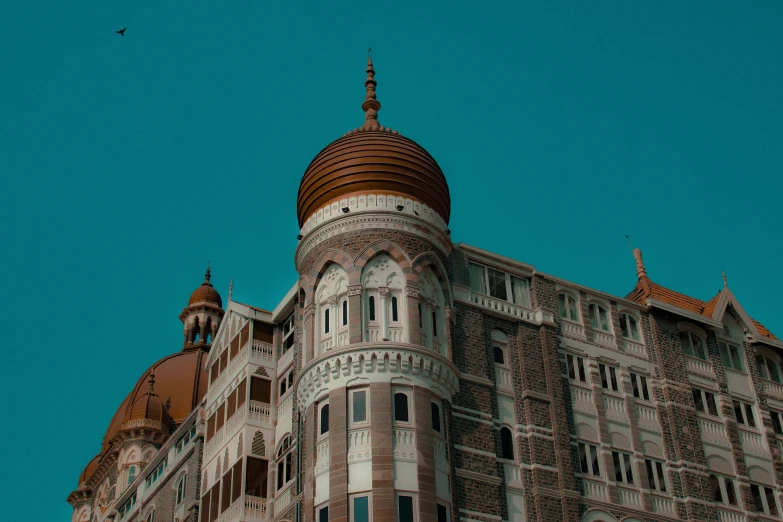 a tall building with a clock on top of it, a colorized photo, pexels contest winner, hindu aesthetic, turrets, brown and cyan color scheme, high forehead