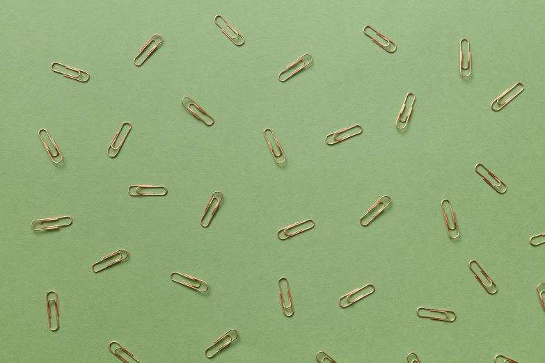 a bunch of paper clips on a green surface, by Emma Andijewska, trending on pexels, computer art, repeating pattern, thin gold details, background image, polka dot