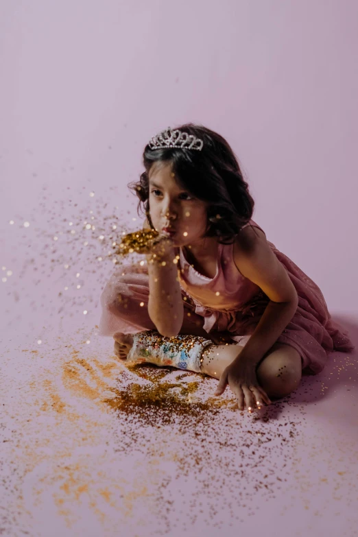 a little girl sitting on the ground next to a cake, pexels contest winner, art photography, gold flakes, of indian princess, glitter background, light scatter