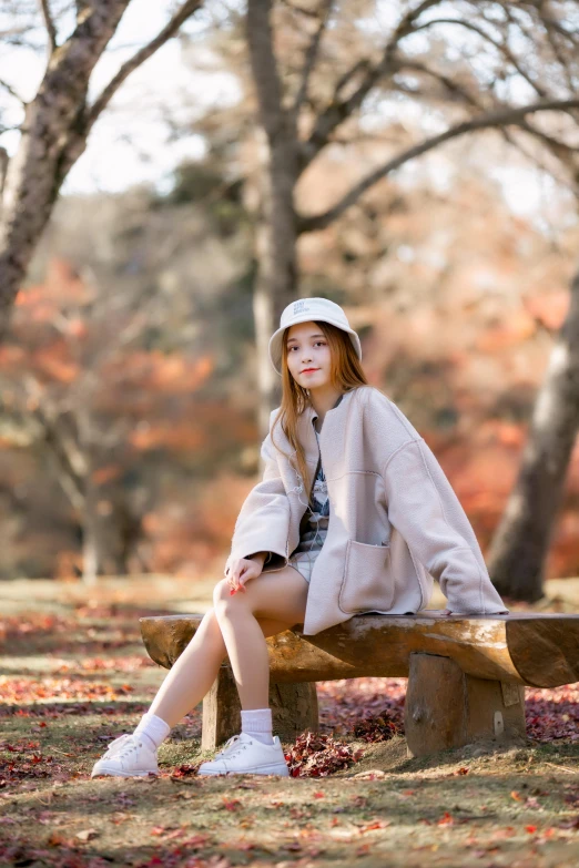 a woman sitting on top of a wooden bench, by Ai-Mitsu, unsplash, light brown coat, teenage girl, white, 15081959 21121991 01012000 4k