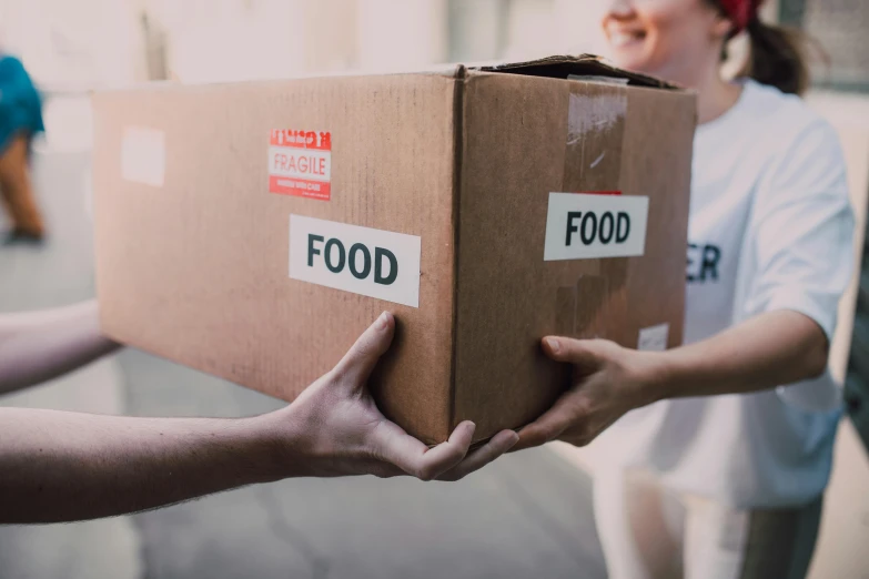 a person holding a box with food on it, by Julia Pishtar, pexels contest winner, hurufiyya, lachlan bailey, corinne day, thumbnail, damaged