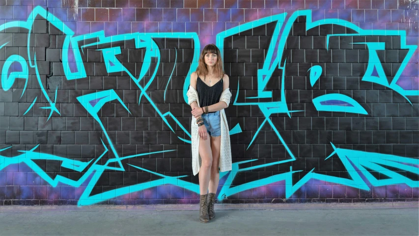 a woman standing in front of a graffiti wall, pexels contest winner, teal studio backdrop, for hire 3d artist, modelling, street wear