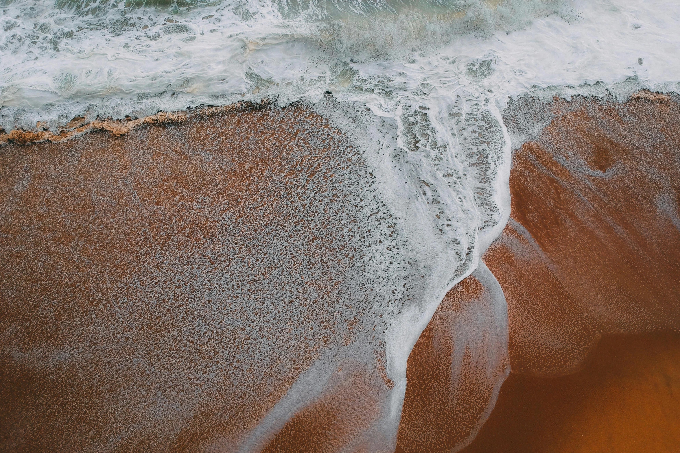 a man riding a surfboard on top of a sandy beach, pexels contest winner, renaissance, water texture, red sand, unsplash transparent fractal, rushing water