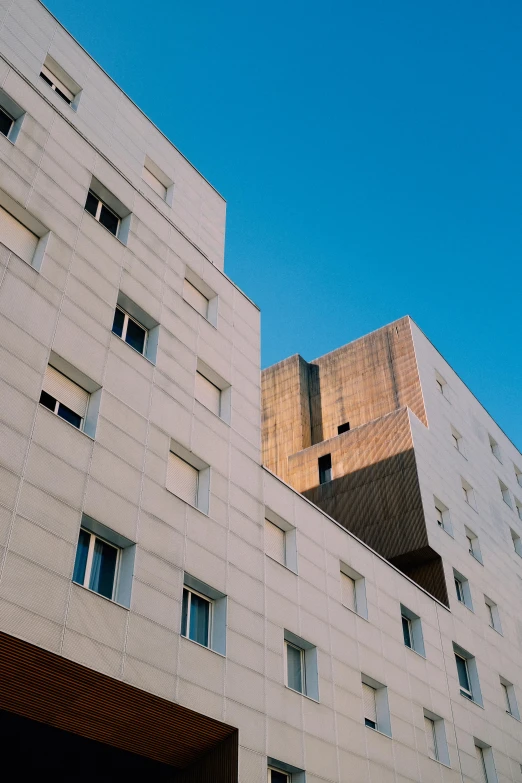 a tall building with a clock on top of it, an album cover, inspired by Ricardo Bofill, unsplash, brutalism, hospital, filtered evening light, ignant, french architecture