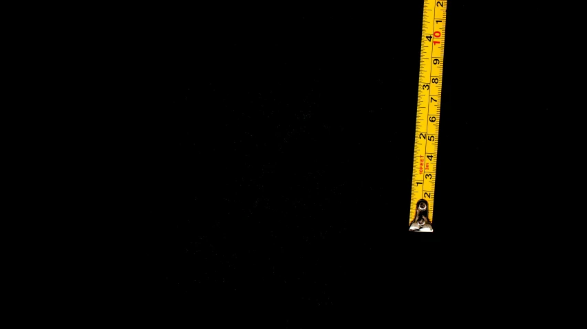 a close up of a ruler on a black background, by Jan Rustem, 8 feet from the camera, ! low contrast!, background image, scale