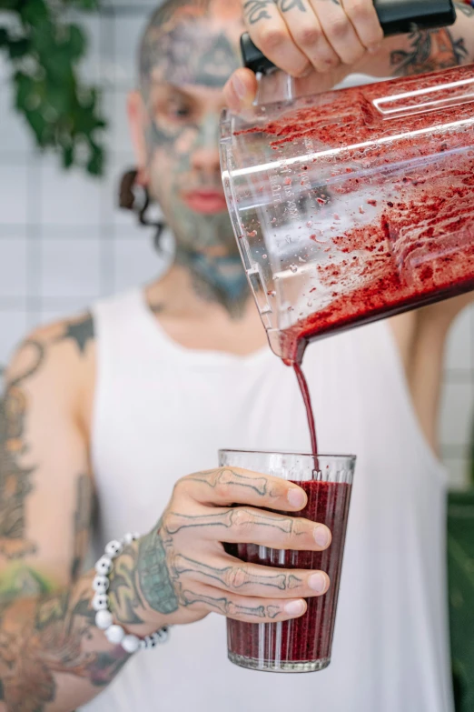 a tattooed man pouring a drink into a glass, trending on pexels, process art, beets, moringa juice, lgbtq, “berries