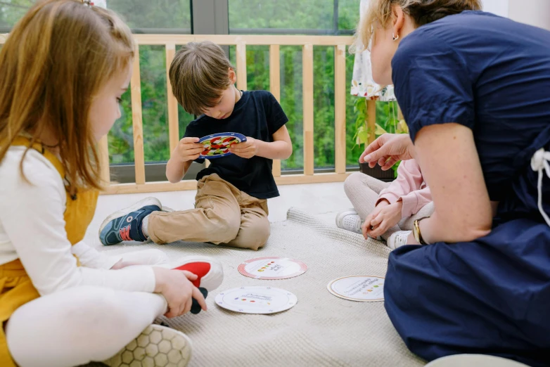 a group of children sitting on the floor playing with paper plates, a picture, by Emma Andijewska, pexels contest winner, trade card game, profile image, at home, thumbnail