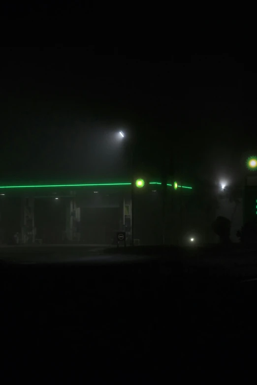 a gas station at night with green lights, a picture, by Peter Churcher, conceptual art, fog!!!, 2 5 6 x 2 5 6 pixels, foggy photo 8 k, spooky photo