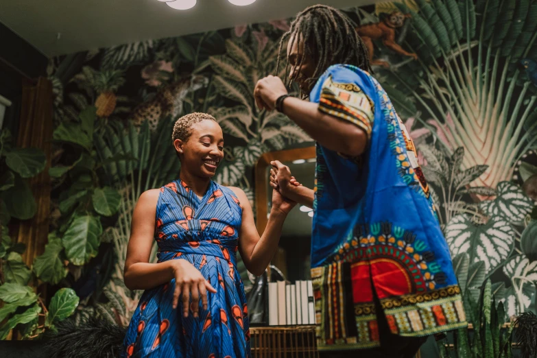 a man standing next to a woman in a blue dress, by Julia Pishtar, pexels contest winner, afrofuturism, waring a hawaiian shirt, reaching out to each other, kemetic, joyful people in the house